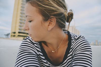 Close-up of young woman against sky