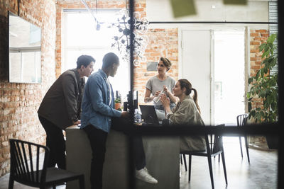 Male and female hackers discussing at creative office