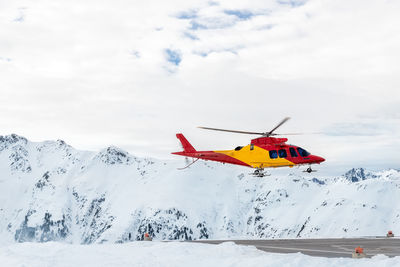 Low angle view of helicopter flying against sky during winter