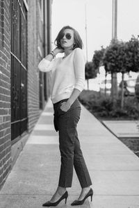 Portrait of woman standing on footpath