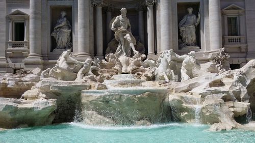 Statue of fountain in front of historical building