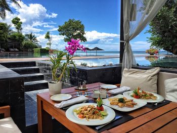 Seafood served in plates on table by infinity pool at hotel