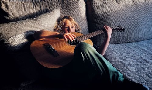 Midsection of woman playing guitar