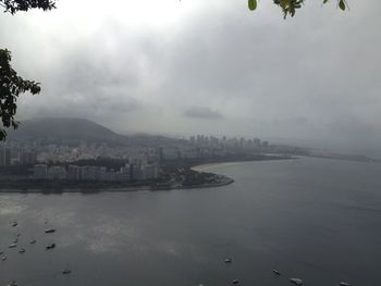Buildings by sea against sky in city