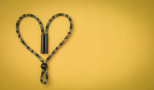 Close-up of heart shape against orange wall