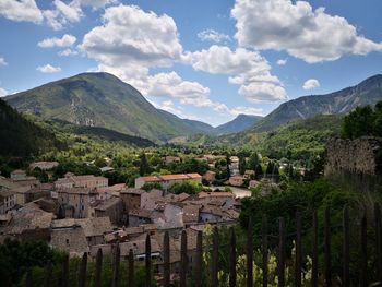 Scenic view of trees and houses against sky