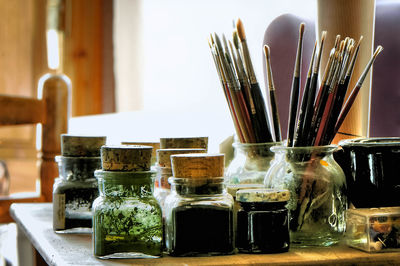 Close-up of paintbrushes in jar on table