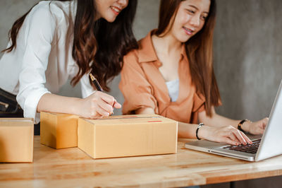 Young woman using mobile phone on table