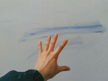 Close-up of hand against wall