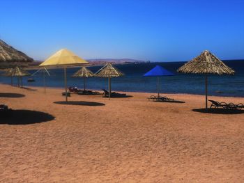 Scenic view of beach against clear blue sky