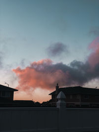 Smoke emitting from building against sky during sunset