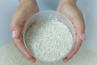 Cropped hands holding rice in bowl