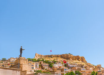 Buildings in town against clear blue sky