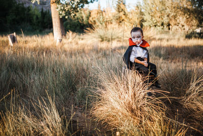 Portrait of boy sitting on field