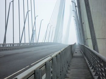 Surface level of footbridge over road against sky  in the strong fog mist