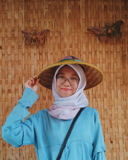 Portrait of smiling woman wearing asian style conical hat 