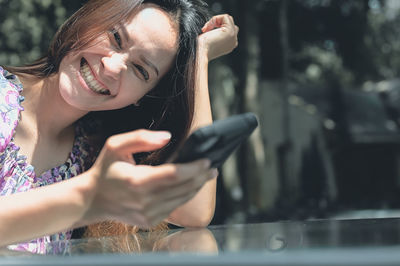 Young woman grinning and hand holding mole phone