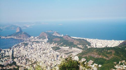 High angle view of town by sea against sky