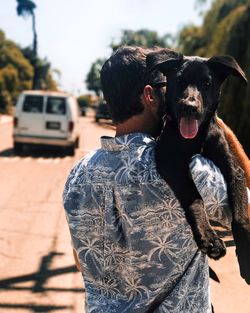 Man with dog standing against sky