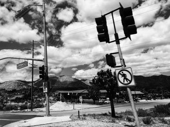 Road sign against cloudy sky