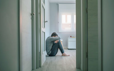 Side view of young woman looking through window