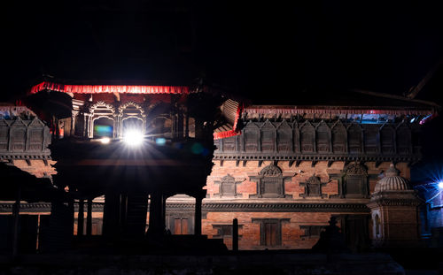 Low angle view of illuminated building against sky at night