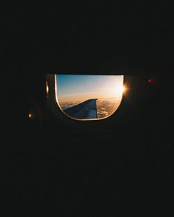 Airplane window against sky at night