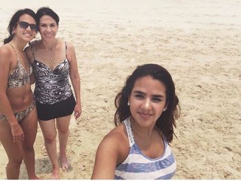 Portrait of smiling young woman standing at beach