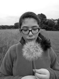 Close-up of teenage girl blowing dandelion while