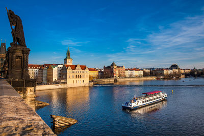 Boats in river against buildings in city