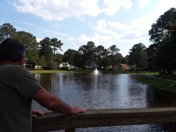 Man standing by trees against sky