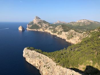 Scenic view of sea and mountains against clear blue sky