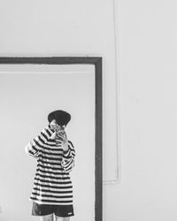 Man standing against wall at home