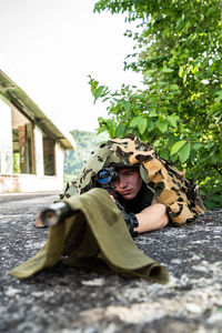 Soldier aiming gun while lying on land