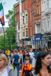 People on street against buildings in city