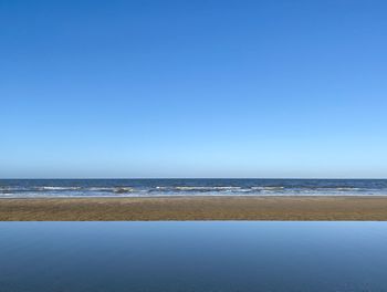 Scenic view of sea against clear blue sky