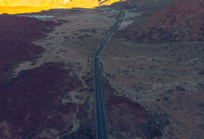 High angle view of road amidst field against sky