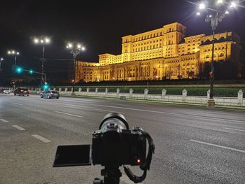 Illuminated street light on road in city at night