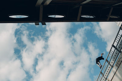 Low angle view of man working against sky