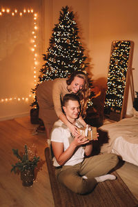A romantic couple in love celebrates christmas holidays and new year in a cozy house at night
