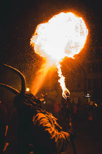 Midsection of man holding fire at night