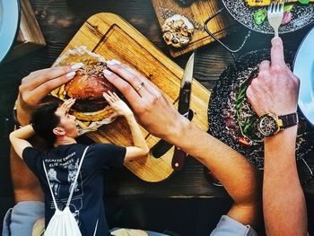 High angle view of people holding food on table