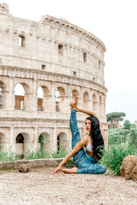 Woman sitting on historical building