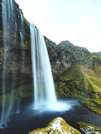 Scenic view of waterfall against sky