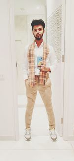 Portrait of smiling young man standing at home