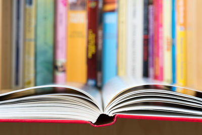 Open book with a bookshelf on the background