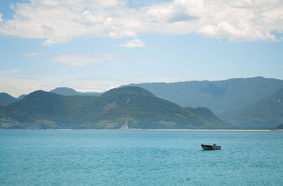 Scenic view of sea and mountains against sky