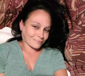 Portrait of smiling woman relaxing on bed