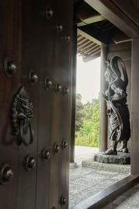 Close-up of statue against window of building