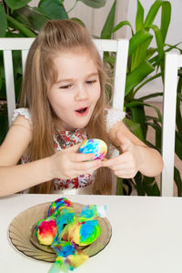 Cute girl painting egg at home